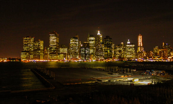 View of the night Manhattan, the lights of skyscrapers glowing at night against the black sky, USA photo