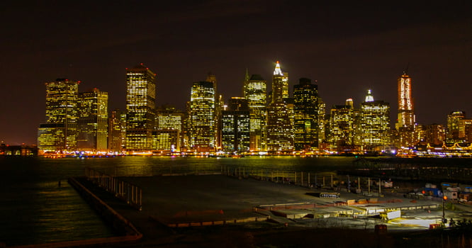 View of the night Manhattan, the lights of skyscrapers glowing at night against the black sky, USA photo