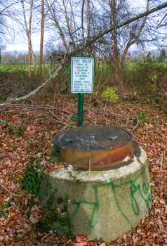 New Jersey, USA - November 19, 2009 - sewer well with warning sign in a city park in the suburbs of New Jersey, USA photo
