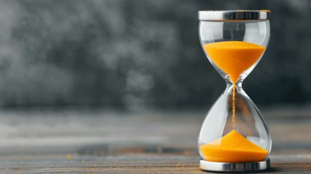 Yellow Sand Hourglass Surrounded by Flowers on Wooden Surface photo