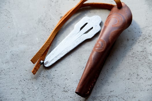 Jew's harp in a brown genuine leather case on a gray background. Sound therapy photo