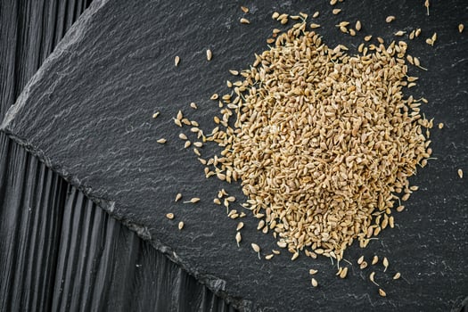 aromatic dry anise seeds on a dark black stone background photo