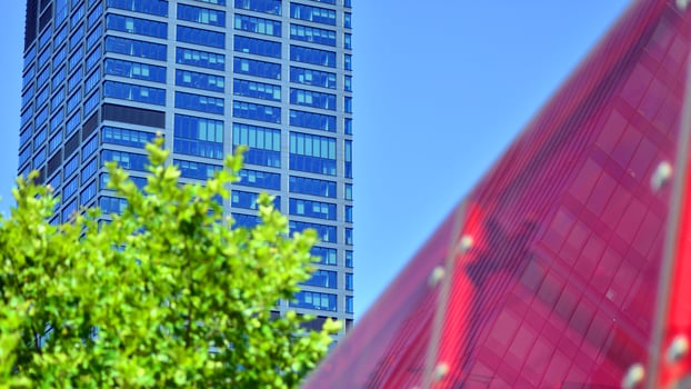 City life, urban landscape and ecology. Modern office complex with glass facades and smooth lines against backdrop of green trees, concept of modern architecture. Organically building into nature. photo