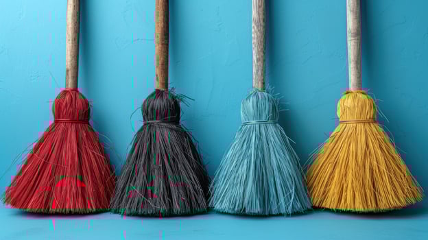 Four Brooms Aligned Agnst a Blue Wall photo