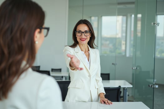 photo of woman in white blazer with open hand and colleagues meeting promote in the office,