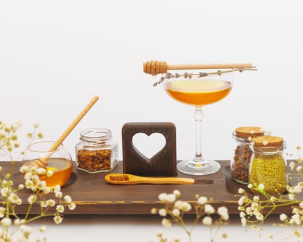 Bee products and honey in glass jars on a wooden board photo