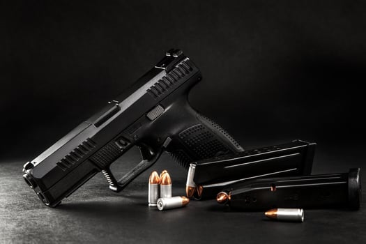 black pistol and cartridges on a black background photo