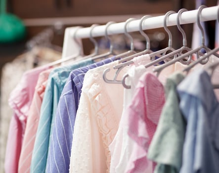 Colorful women's dresses on hangers in a retail shop. Fashion and shopping concept. Variety of different female colorful clothing hanging. photo