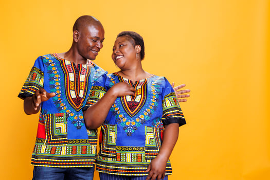 Smiling man and woman couple looking at each other with affection, showing love and happiness while standing together. Cheerful black wife and husband family posing in studio photo