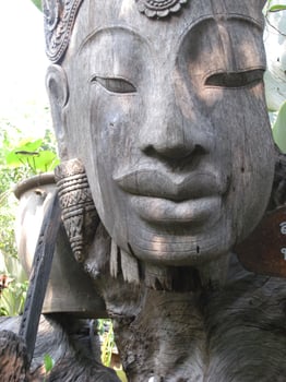 The wood is carved into the shape of a person's face in ancient times. The color is gray wood that has been exposed to the sun and rain over time. photo