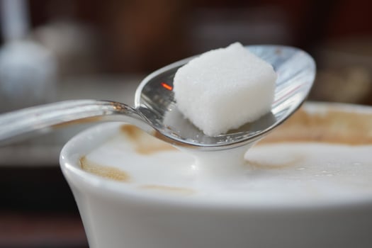 pouring white sugar cube in a coffee cup , photo