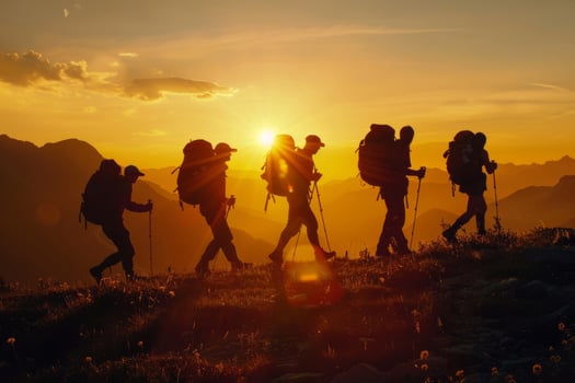 A group of tourists with backpacks walks through the mountains at sunset. The concept of travel, an active lifestyle. photo