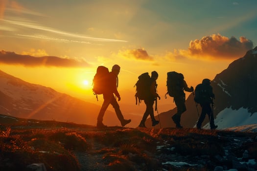 A group of tourists with backpacks walks through the mountains at sunset. The concept of travel, an active lifestyle. photo
