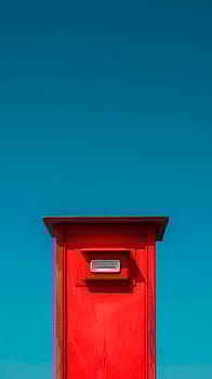 Red Mailbox on Blue Background. Copy space, Postal Service, Communication Symbol, Delivery Icon. photo