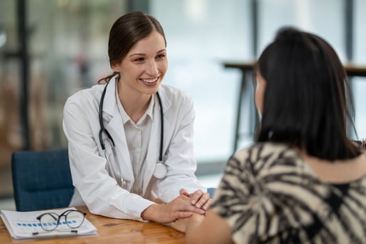 A female doctor showing empathy and comfort to her patient during a consultation in a medical office setting. photo