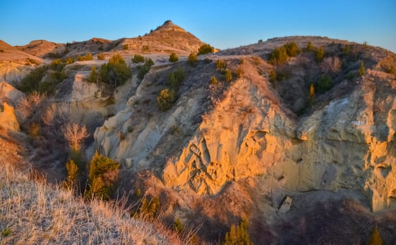 Geological stony-clay landscape, mountains and rocks in the evening at sunset. North Dakota photo