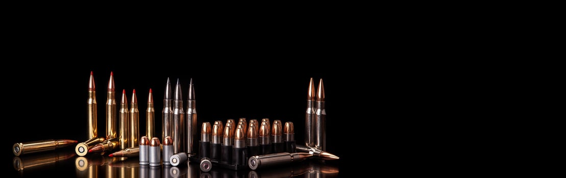 Bullet isolated on black background with reflexion. Rifle bullets close-up on black back. Cartridges for rifle and carbine on a black. photo