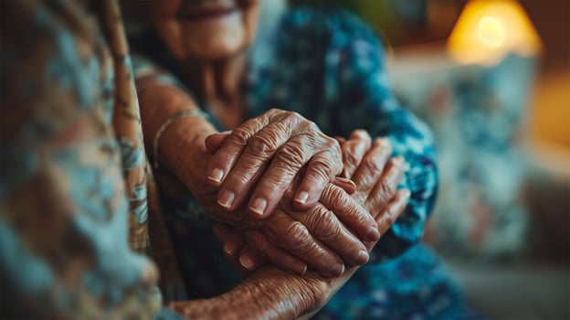 Close-up of seniors holding hands, symbolizing care, support, and affection in a cozy setting. Concept of support and human connection. photo