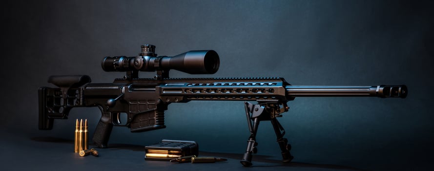Modern powerful sniper rifle with a telescopic sight mounted on a bipod. Ammo and an additional magazine next to the rifle. photo
