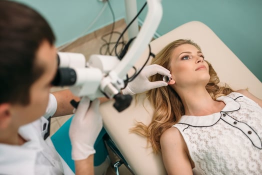 A medical professional examines a patient in a clinic during an ear treatment session photo