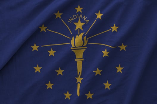 Indiana US state flag depicted on folded wavy fabric of old cloth photo