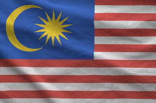 Malaysia flag depicted on folded wavy fabric of old cloth photo