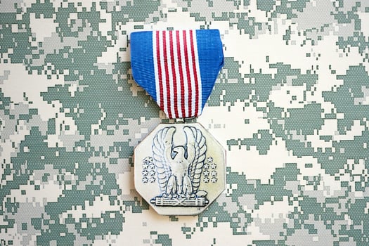 KYIV, UKRAINE - JULY 10, 2024 US Non-Combat Heroism Soldiers medal. United States military award medal with ribbon and pin. Handmade paper theater props photo
