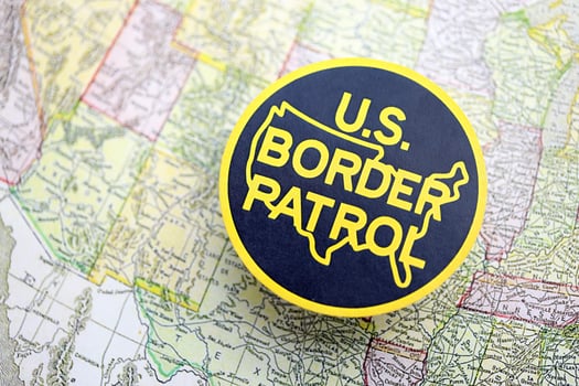 KYIV, UKRAINE - JUNE 26, 2024 U.S. Border Patrol coat of arms on paper map of United States photo