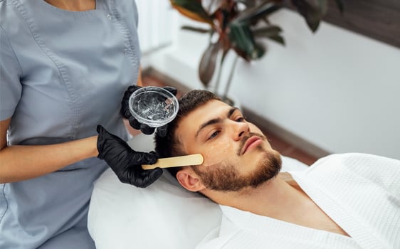 Preparing the skin of young man for laser hair removal of the cheek photo