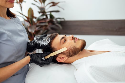 Preparing the skin of young man for laser hair removal of the cheek photo