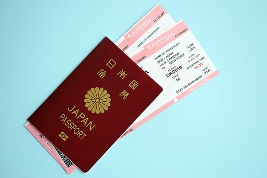 Japan passport with airline tickets on blue background close up photo