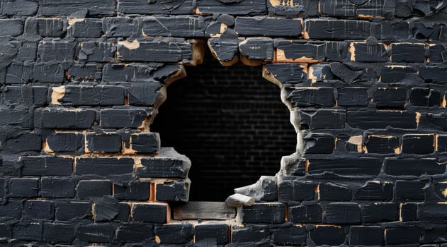 This image shows a large hole in a black brick wall, revealing a mysterious dark space. It represents destruction and urban decay, evoking thoughts on abandonment in contemporary settings photo