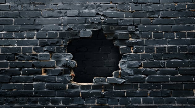 This is a closeup view showcasing a damaged black brick wall that features a prominent and noticeable hole, effectively highlighting the various textures and beautifully distressed surfaces present photo