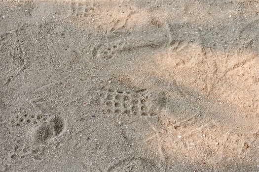 Beach sand ground flooring texture with shoeprints isolated on horizontal ratio background. photo