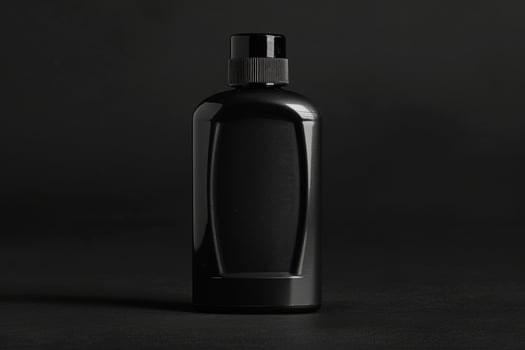 A stylish black bottle of mens shampoo stands alone, showcasing its modern design and elegance in a minimalist environment. photo