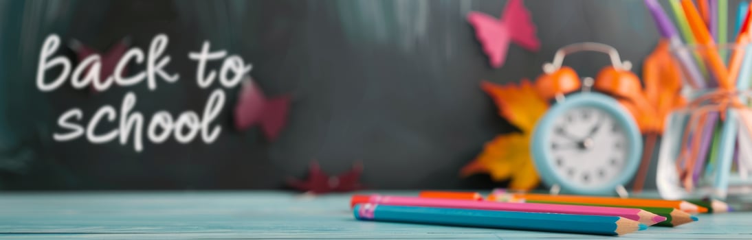 Back To School Themed Chalkboard With Colorful Pencils And A Clock photo