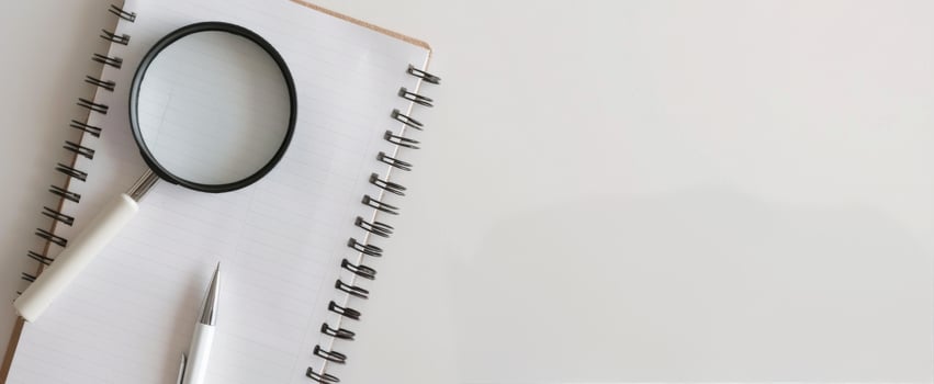 Magnifying Glass on Documents With Pink Pen in Brightly Lit Workspace photo