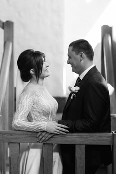 the first meeting of the bride and groom on a wooden staircase photo