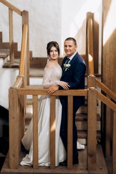 the first meeting of the bride and groom on a wooden staircase photo