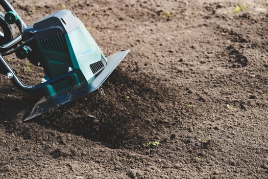 farmer prepares the soil for planting with electric cultivator photo