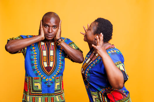 Angry african american wife shouting while husband covering ears with hands and looking at camera. Man ignoring while having argument and relationship crisis with girlfriend photo