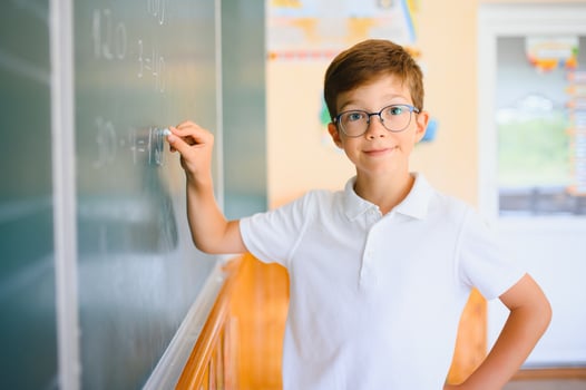 Schoolboy near blackboard in classroom photo