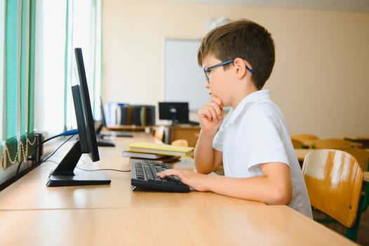 Little schoolboy during lesson in classroom photo