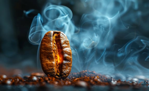 Coffee bean glowing with smoke against a dark background. A single coffee bean emits a warm glow surrounded by swirling smoke photo