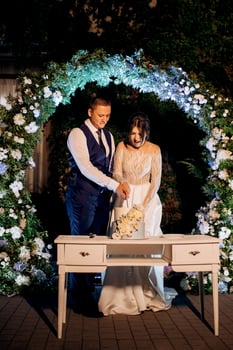 newlyweds happily cut and taste the wedding cake photo