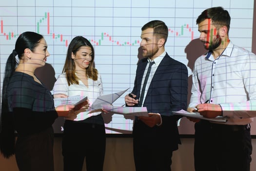 Group of business people working at modern office.Technical price graph, red and blue candlestick chart and stock trading computer screen background. Double exposure. Traders analyzing data photo