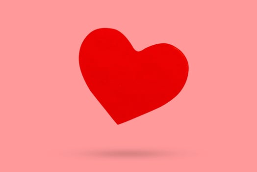 red heart shape sticker isolated on pink background photo