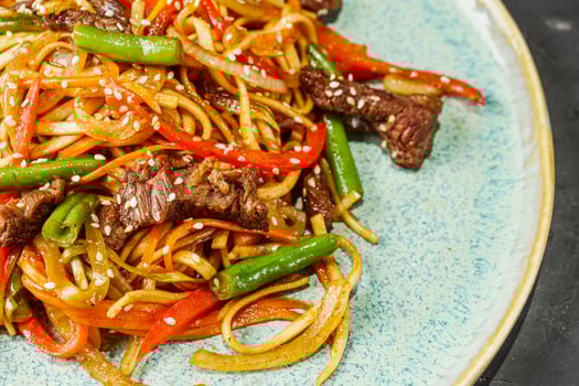 fried wok beef noodles on a black rustic background photo