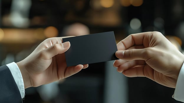 a photo of someone handing another person a black business card