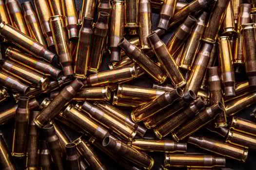 Background from empty cartridges for rifles and carbines. Shiny brass shells scattered on the surface. photo